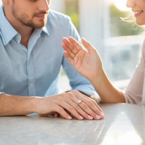 Man proposing to woman with diamond ring on her finger